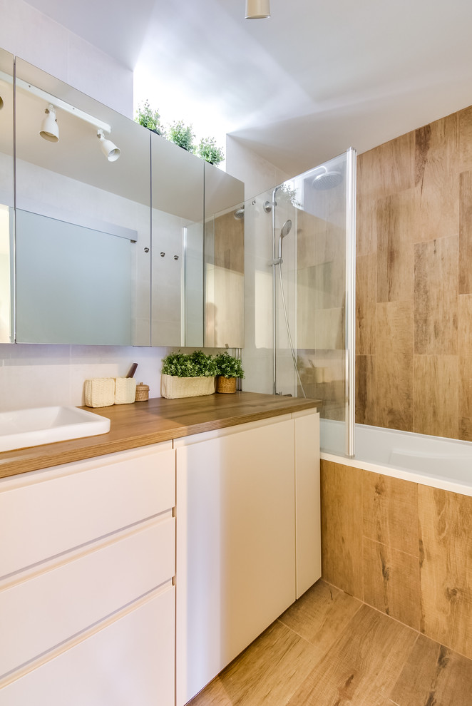 Modern inredning av ett brun brunt badrum, med släta luckor, vita skåp, ett platsbyggt badkar, en dusch/badkar-kombination, brun kakel, vita väggar, ett nedsänkt handfat och brunt golv