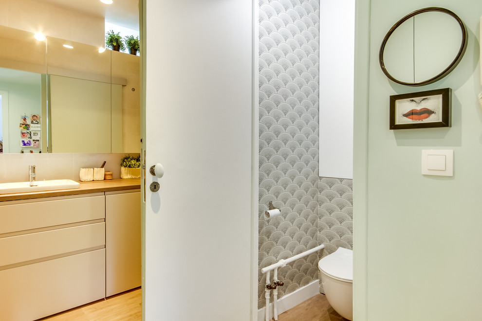 Réalisation d'une salle de bain design avec un placard à porte plane, des portes de placard blanches, WC suspendus, un mur blanc, un lavabo posé, un sol marron, un plan de toilette marron et des toilettes cachées.