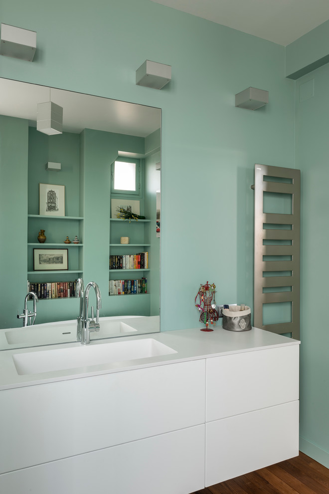 Imagen de cuarto de baño moderno con bañera exenta, ducha a ras de suelo, paredes verdes, suelo de madera clara y encimera de acrílico