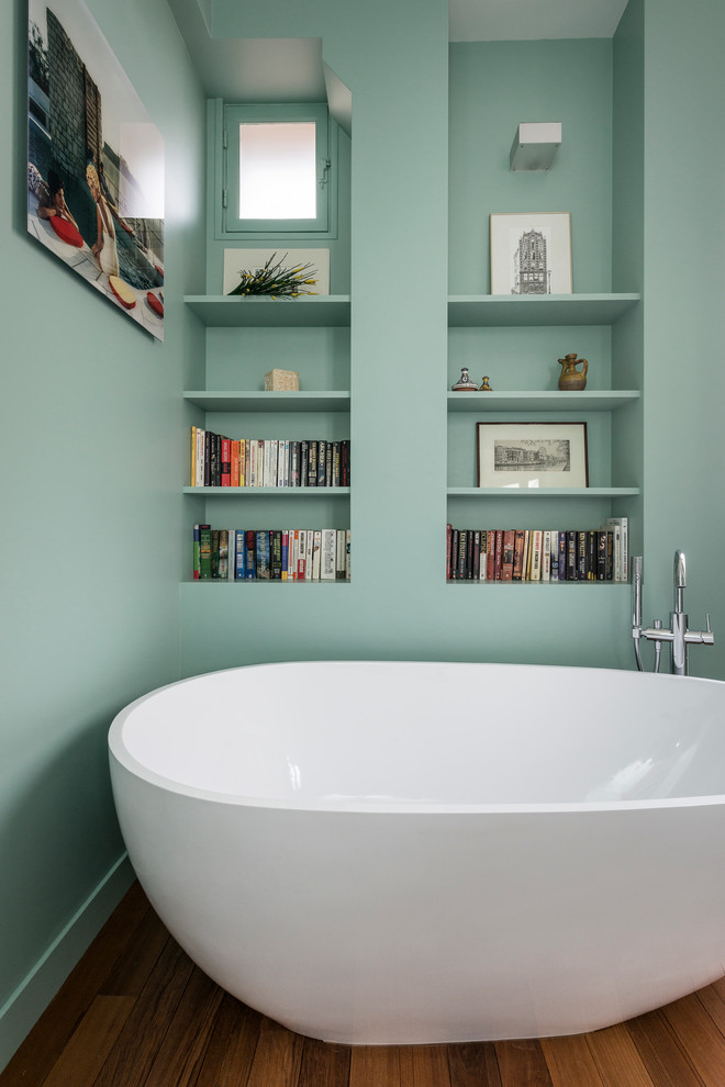 Kleines Modernes Badezimmer En Suite mit offenen Schränken, freistehender Badewanne, grüner Wandfarbe und braunem Holzboden in Paris