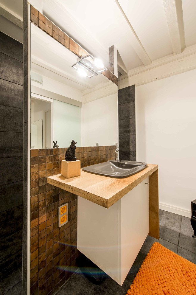 Exemple d'une salle d'eau tendance avec un placard à porte affleurante, des portes de placard blanches, une douche à l'italienne, un carrelage gris, carrelage en métal, un mur blanc, un sol en carrelage de céramique, un lavabo encastré et un plan de toilette en bois.
