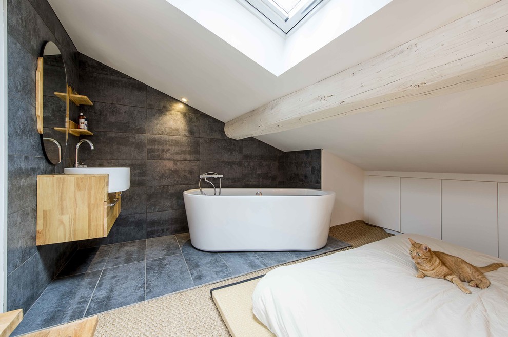Design ideas for a medium sized contemporary ensuite bathroom in Lyon with flat-panel cabinets, wooden worktops, grey tiles, a vessel sink, grey walls, a freestanding bath, white cabinets, ceramic tiles and ceramic flooring.