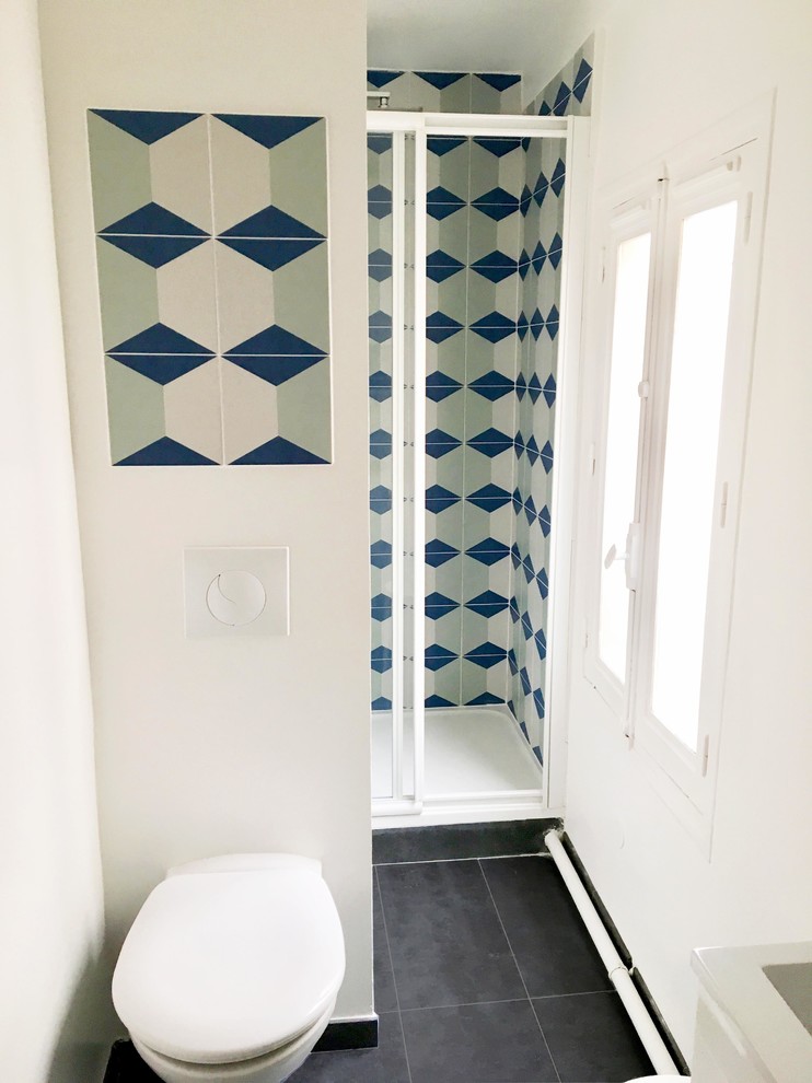 Aménagement d'une petite salle de bain scandinave avec WC suspendus, un carrelage bleu, des carreaux de béton, un mur blanc, un plan vasque, un sol gris, une cabine de douche à porte coulissante et un plan de toilette blanc.
