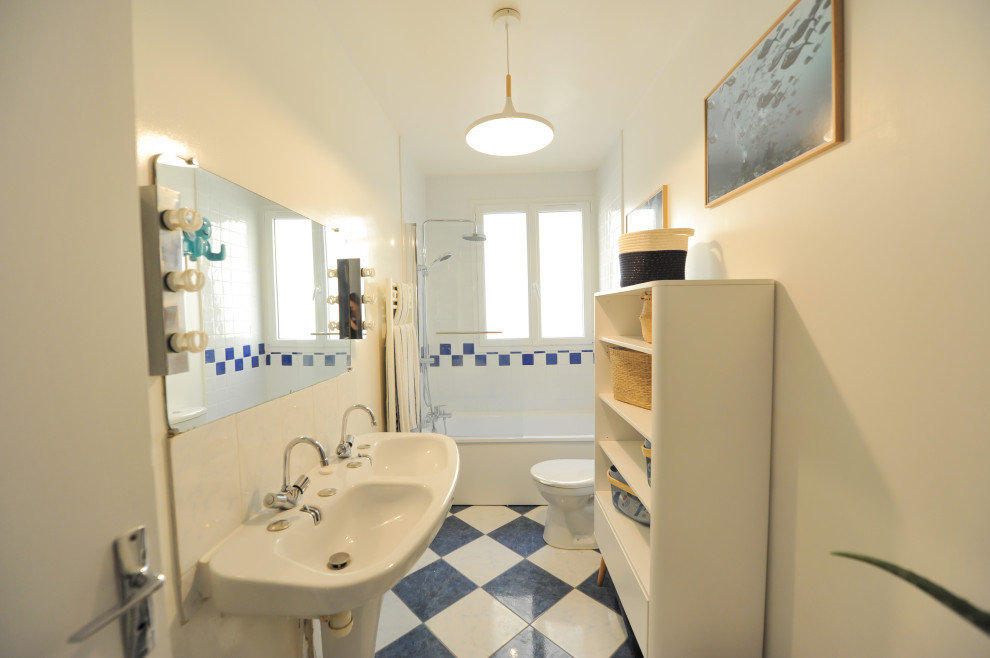 Exemple d'une petite salle de bain principale avec des portes de placard blanches, une baignoire posée, un carrelage bleu, des carreaux de céramique, un mur blanc, un sol en carrelage de céramique, une grande vasque, un sol bleu et aucune cabine.