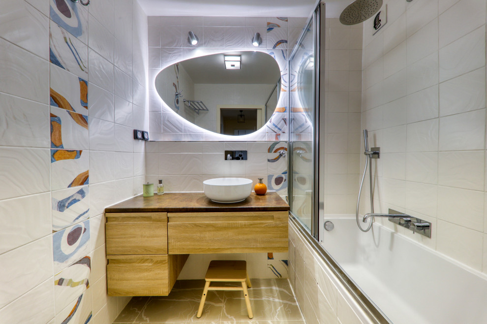 Inspiration för ett litet eklektiskt en-suite badrum, med ett badkar i en alkov, en dusch/badkar-kombination, flerfärgad kakel, vita väggar, klinkergolv i keramik, ett avlångt handfat, laminatbänkskiva, beiget golv, skåp i ljust trä och porslinskakel