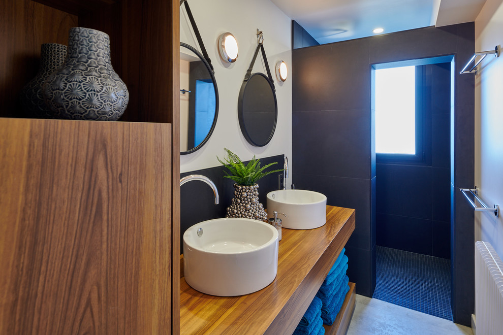 Свежая идея для дизайна: ванная комната среднего размера в стиле фьюжн с коричневыми фасадами, открытым душем, белой плиткой, черной плиткой, плиткой из сланца, белыми стенами, бетонным полом, настольной раковиной, столешницей из дерева, серым полом, открытым душем и коричневой столешницей - отличное фото интерьера