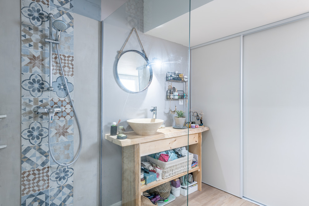 This is an example of a medium sized ensuite bathroom in Bordeaux with open cabinets, a built-in shower, white tiles, blue tiles, grey tiles, ceramic tiles, grey walls, light hardwood flooring, a built-in sink, wooden worktops, brown floors and an open shower.