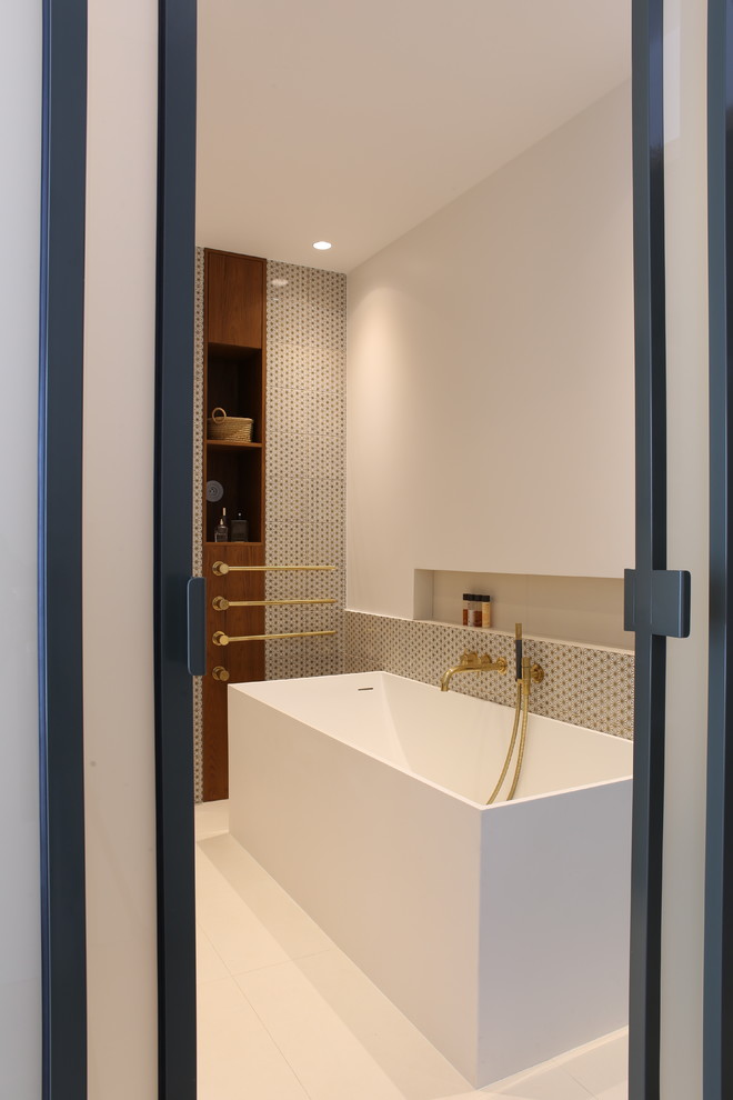 Inspiration pour une salle de bain principale design de taille moyenne avec une baignoire indépendante, un carrelage blanc, des carreaux de béton, carreaux de ciment au sol, un sol blanc et un plan de toilette blanc.