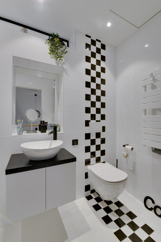 Идея дизайна: детская ванная комната среднего размера в стиле модернизм с плоскими фасадами, белыми фасадами, белой плиткой, черной плиткой, черно-белой плиткой, керамической плиткой, столешницей из ламината, черной столешницей, полновстраиваемой ванной, душем над ванной, инсталляцией, белыми стенами, полом из керамической плитки, накладной раковиной, белым полом и душем с распашными дверями