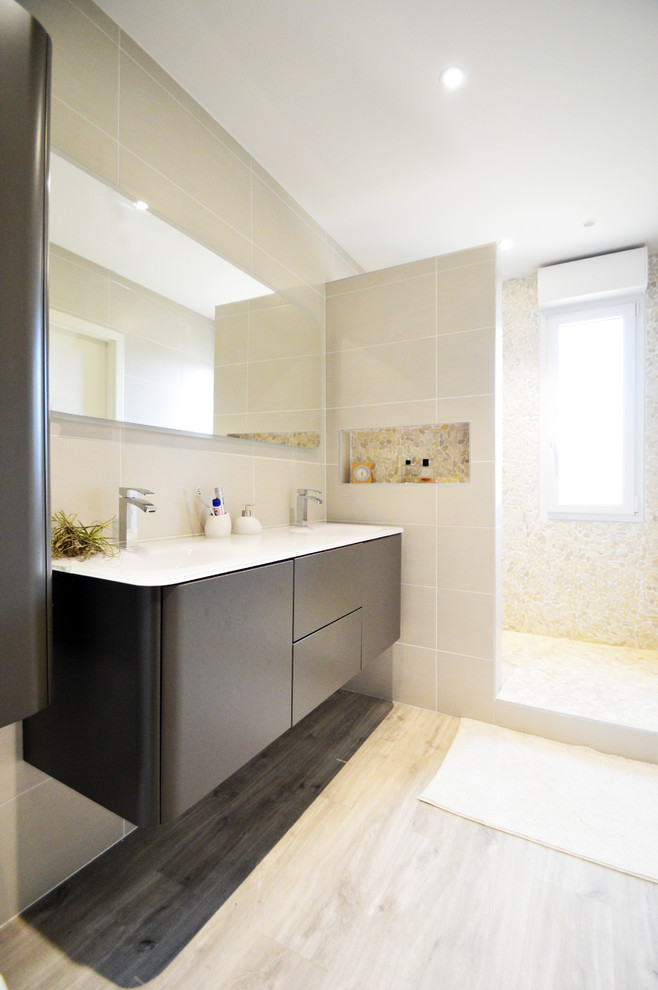 Idee per una stanza da bagno padronale design con ante lisce, ante nere, doccia alcova, piastrelle beige, pareti beige, parquet chiaro, lavabo integrato e doccia aperta