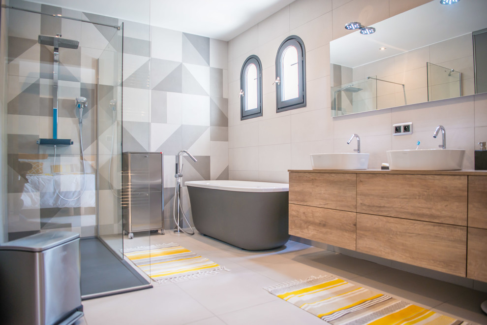 Photo of a large contemporary ensuite bathroom in Marseille with medium wood cabinets, a freestanding bath, a built-in shower, white tiles, ceramic tiles, ceramic flooring, laminate worktops, white floors, flat-panel cabinets and a vessel sink.