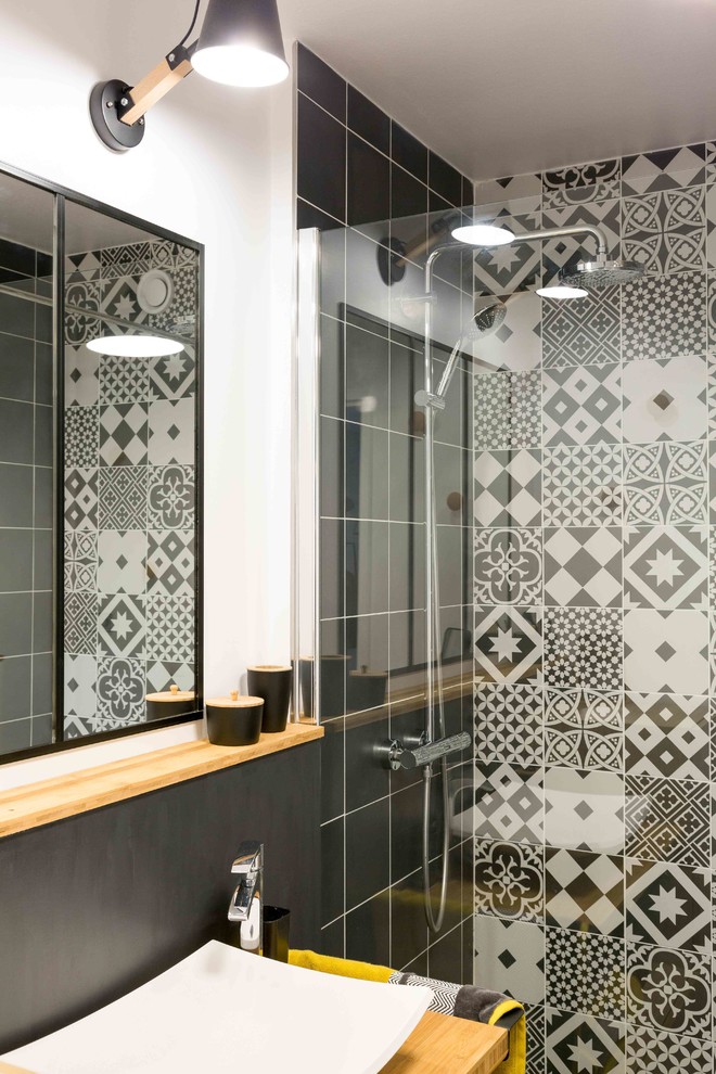 Aménagement d'une salle de bain principale contemporaine de taille moyenne avec une douche ouverte, un carrelage noir et blanc, des carreaux de béton, un mur blanc, un sol en bois brun et une vasque.