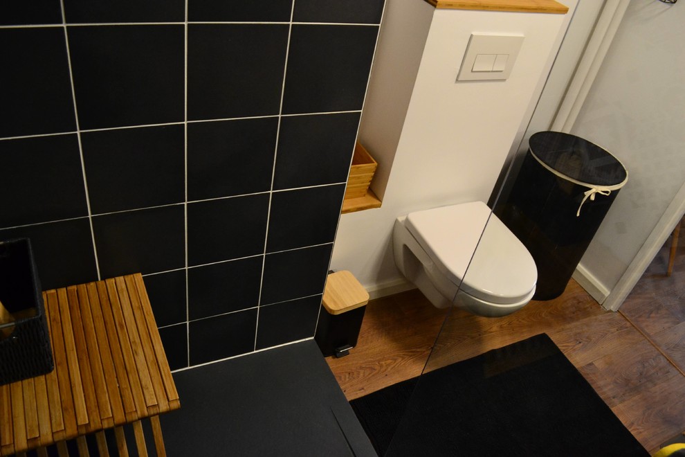 Réalisation d'une salle de bain principale design de taille moyenne avec une douche ouverte, WC suspendus, un carrelage noir et blanc, des carreaux de béton, un mur blanc, un sol en bois brun, un lavabo posé et un plan de toilette en bois.