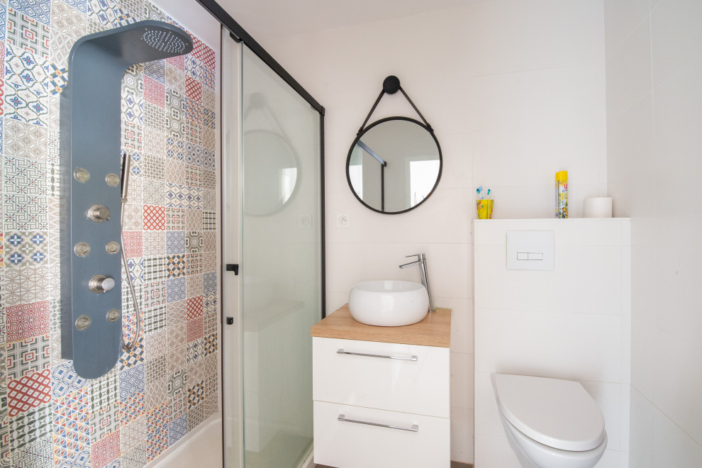 Inspiration for a small industrial 3/4 multicolored tile and ceramic tile cement tile floor, gray floor and single-sink bathroom remodel in Nantes with white cabinets, a wall-mount toilet, multicolored walls, a drop-in sink, wood countertops, beige countertops and a floating vanity
