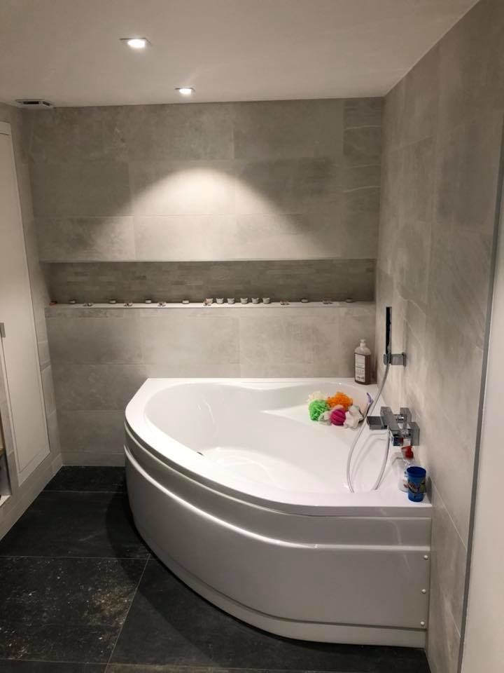 Пример оригинального дизайна: главная ванная комната среднего размера в стиле модернизм с фасадами с декоративным кантом, серыми фасадами, угловой ванной, душем без бортиков, серой плиткой, керамической плиткой, серыми стенами, полом из керамической плитки, консольной раковиной, черным полом, открытым душем, нишей, тумбой под две раковины и встроенной тумбой