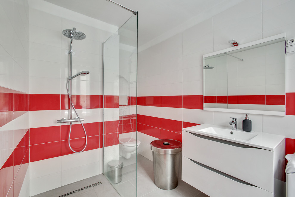 Cette image montre une salle de bain design avec WC suspendus et un sol gris.