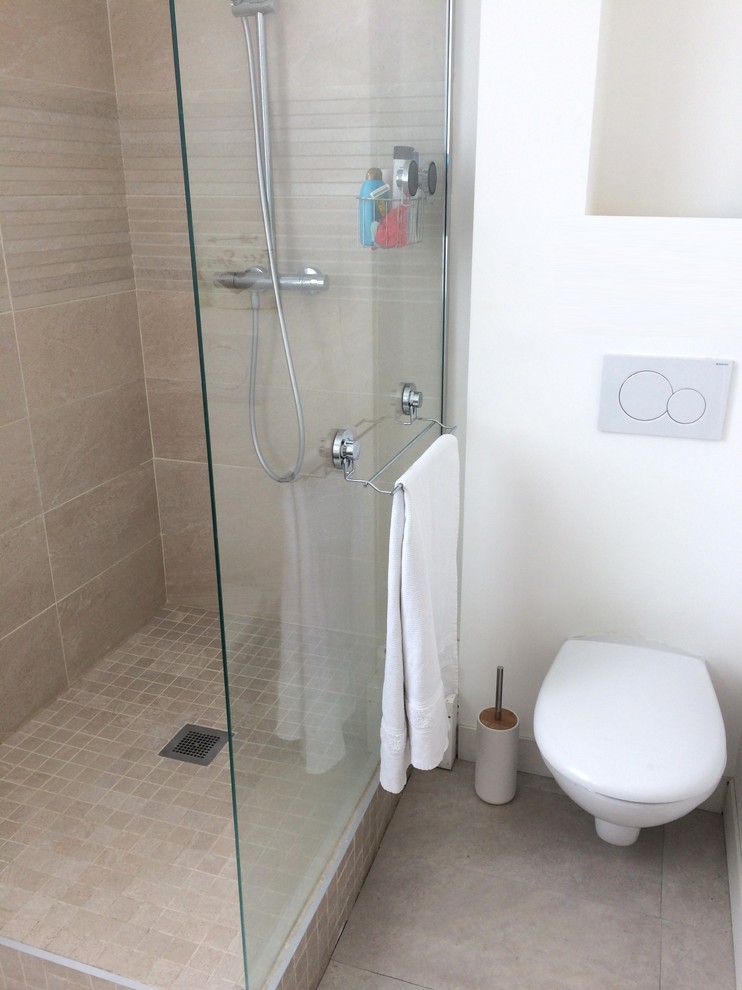 Exempel på ett mellanstort modernt beige beige en-suite badrum, med släta luckor, beige skåp, en hörndusch, en vägghängd toalettstol, beige kakel, keramikplattor, vita väggar, klinkergolv i keramik, ett fristående handfat, träbänkskiva, rosa golv och med dusch som är öppen