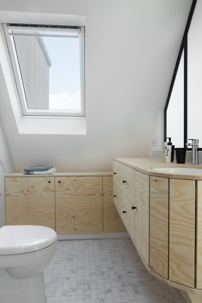 Immagine di una piccola stanza da bagno padronale tropicale con ante di vetro, ante beige, pistrelle in bianco e nero, lavabo sospeso, top in legno e porta doccia a battente