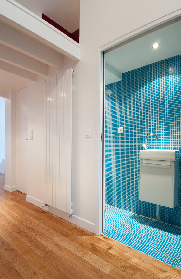Ejemplo de cuarto de baño moderno pequeño con puertas de armario blancas, baldosas y/o azulejos azules, paredes azules, aseo y ducha, lavabo suspendido, suelo azul, baldosas y/o azulejos en mosaico y suelo con mosaicos de baldosas