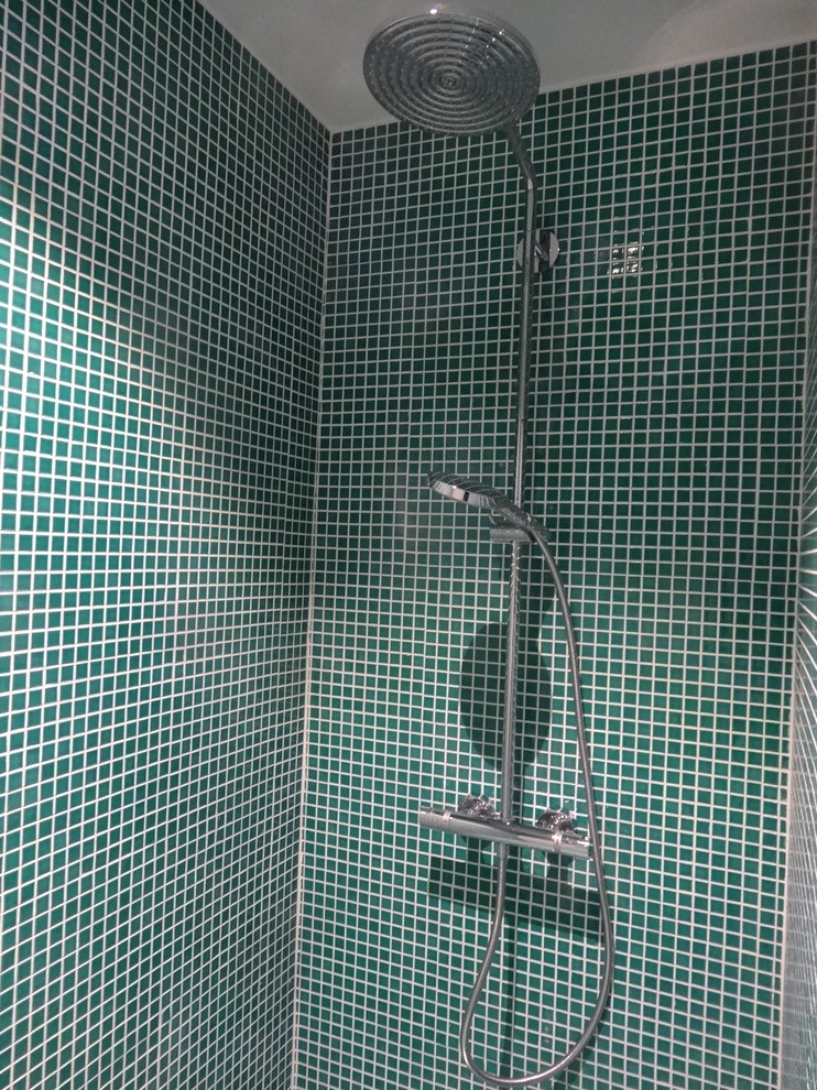 Cette image montre une salle de bain design de taille moyenne avec une douche ouverte, un carrelage vert, des carreaux de porcelaine, un mur vert, carreaux de ciment au sol, une grande vasque, un plan de toilette en carrelage, un sol blanc et aucune cabine.