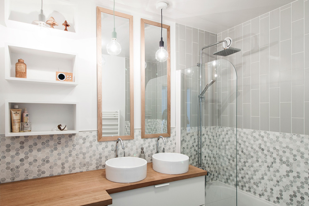 На фото: главная ванная комната в современном стиле с плоскими фасадами, белыми фасадами, ванной в нише, душем в нише, белыми стенами, настольной раковиной, столешницей из дерева, открытым душем и коричневой столешницей