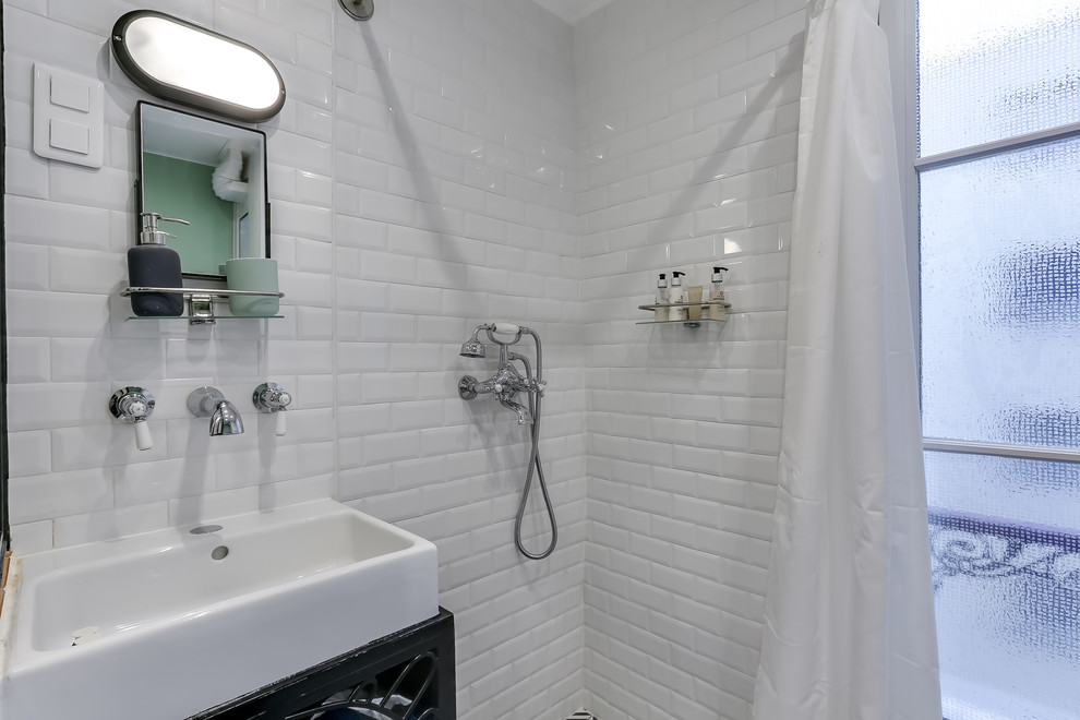 Foto på ett litet retro vit en-suite badrum, med öppna hyllor, svarta skåp, en kantlös dusch, en vägghängd toalettstol, vit kakel, tunnelbanekakel, vita väggar, klinkergolv i keramik, ett nedsänkt handfat, vitt golv och dusch med duschdraperi