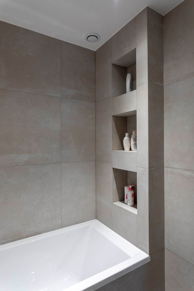 Modern inredning av ett mellanstort vit vitt en-suite badrum, med vita skåp, ett undermonterat badkar, en dusch/badkar-kombination, beige kakel, keramikplattor, beige väggar, klinkergolv i keramik, ett avlångt handfat, beiget golv och med dusch som är öppen