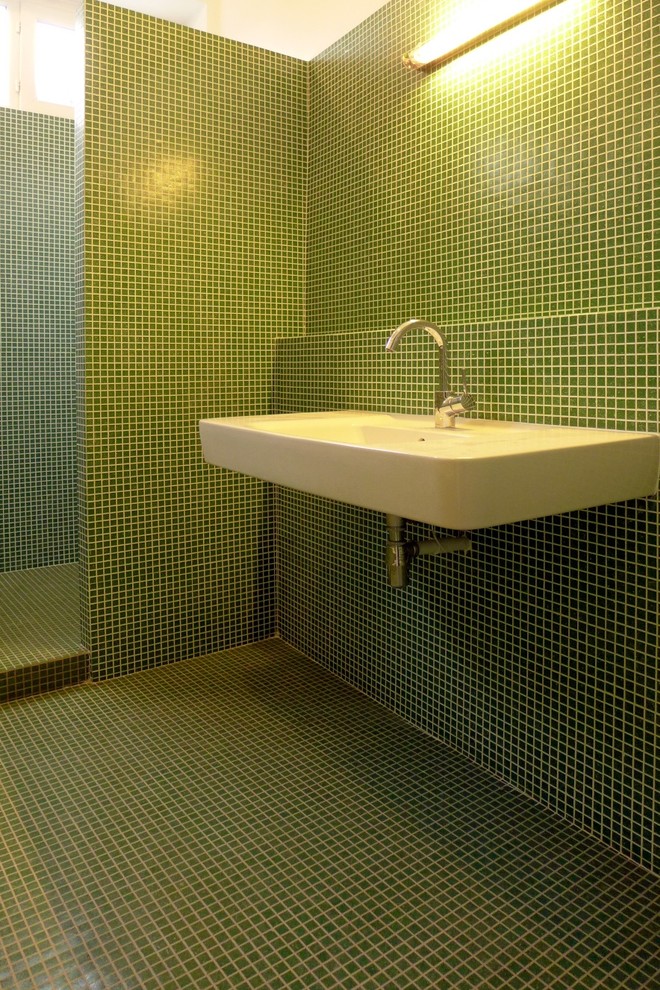 Inspiration pour une salle de bain principale design de taille moyenne avec une baignoire encastrée, une douche à l'italienne, un carrelage vert, un carrelage en pâte de verre, un mur vert, un sol en carrelage de céramique, un lavabo suspendu et un plan de toilette en carrelage.