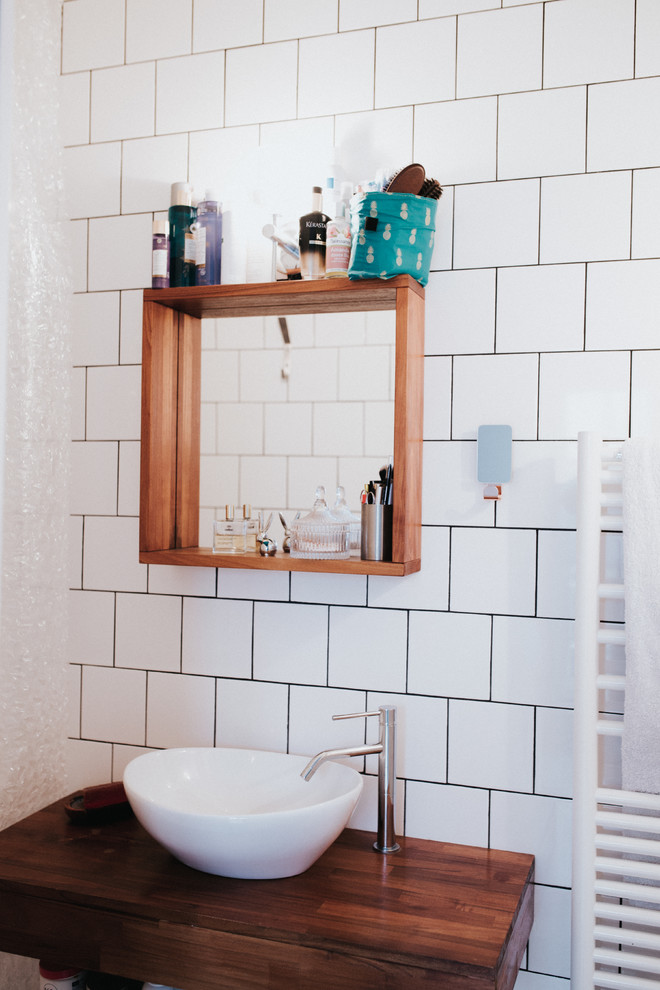 Свежая идея для дизайна: ванная комната в современном стиле с коричневыми фасадами, белой плиткой, удлиненной плиткой, белыми стенами, раковиной с несколькими смесителями и столешницей из дерева - отличное фото интерьера