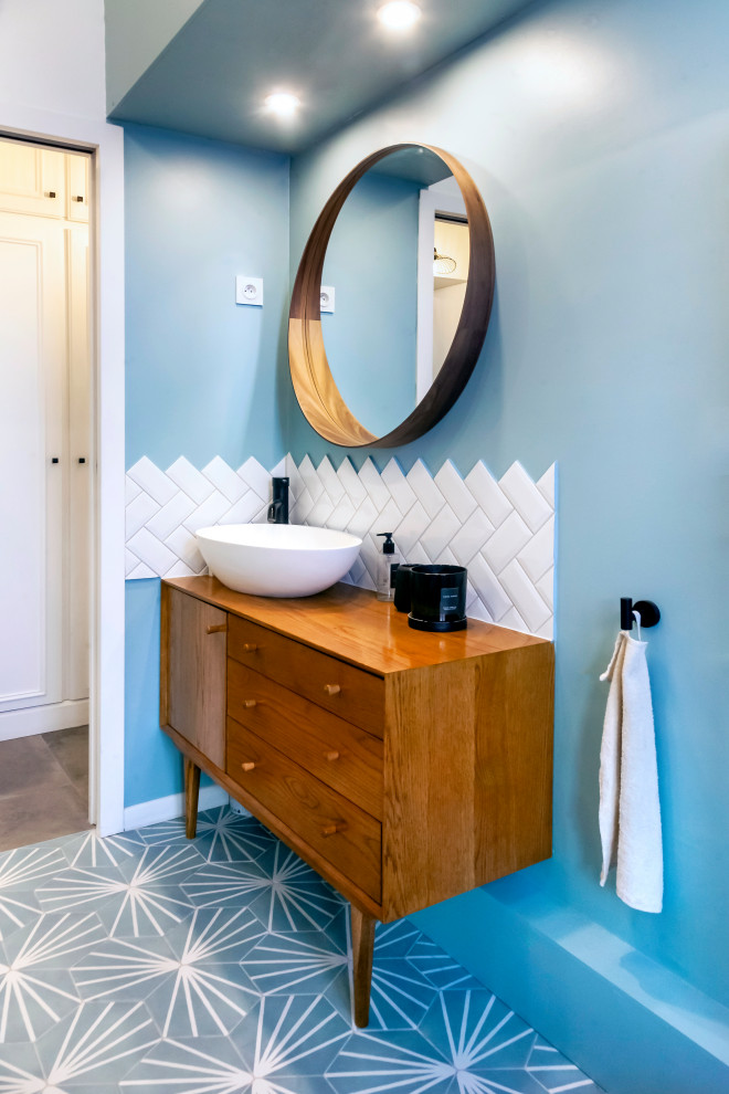Exemple d'une petite salle d'eau moderne avec une baignoire posée, une douche à l'italienne, WC suspendus, un carrelage blanc, un carrelage métro, un mur bleu, un sol en carrelage de céramique, un lavabo posé, un sol bleu et une cabine de douche à porte coulissante.