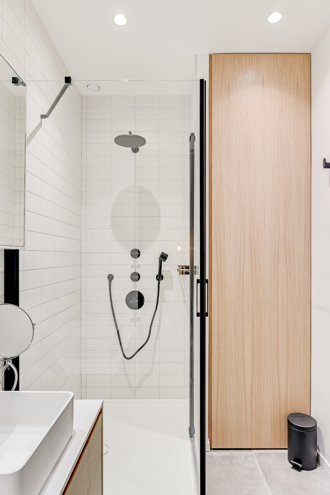 Свежая идея для дизайна: ванная комната в современном стиле с плоскими фасадами, светлыми деревянными фасадами, угловым душем, белой плиткой, белыми стенами, душевой кабиной, настольной раковиной, серым полом, душем с распашными дверями и белой столешницей - отличное фото интерьера