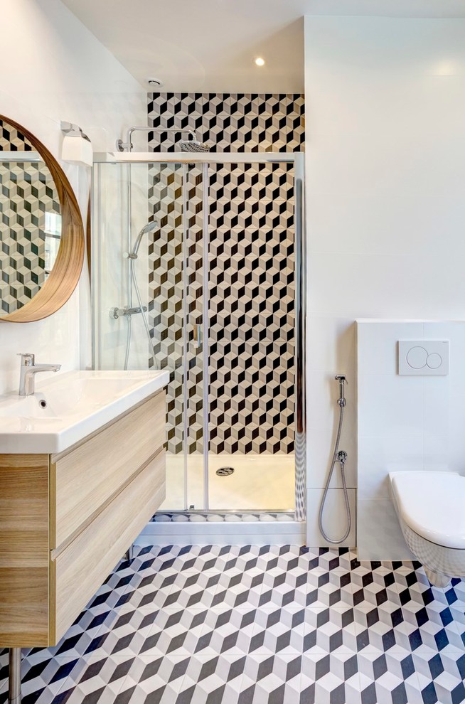 This is an example of a large contemporary ensuite bathroom in Paris with an alcove shower, a wall mounted toilet, black and white tiles, cement tiles, white walls, ceramic flooring, a wall-mounted sink and light wood cabinets.
