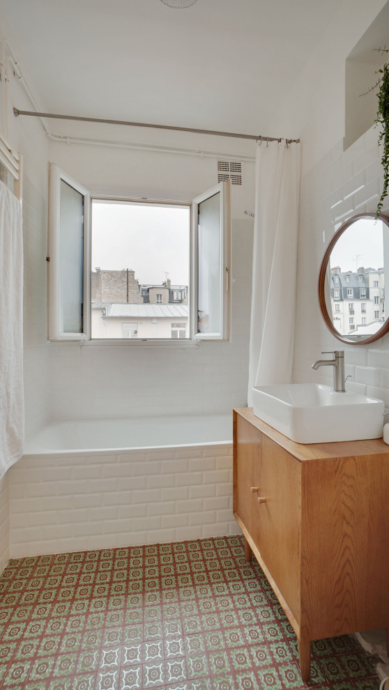 Cette photo montre une salle de bain tendance avec une baignoire encastrée, un carrelage blanc, un carrelage métro, un mur blanc, tomettes au sol, un lavabo posé, un plan de toilette en bois et un sol vert.