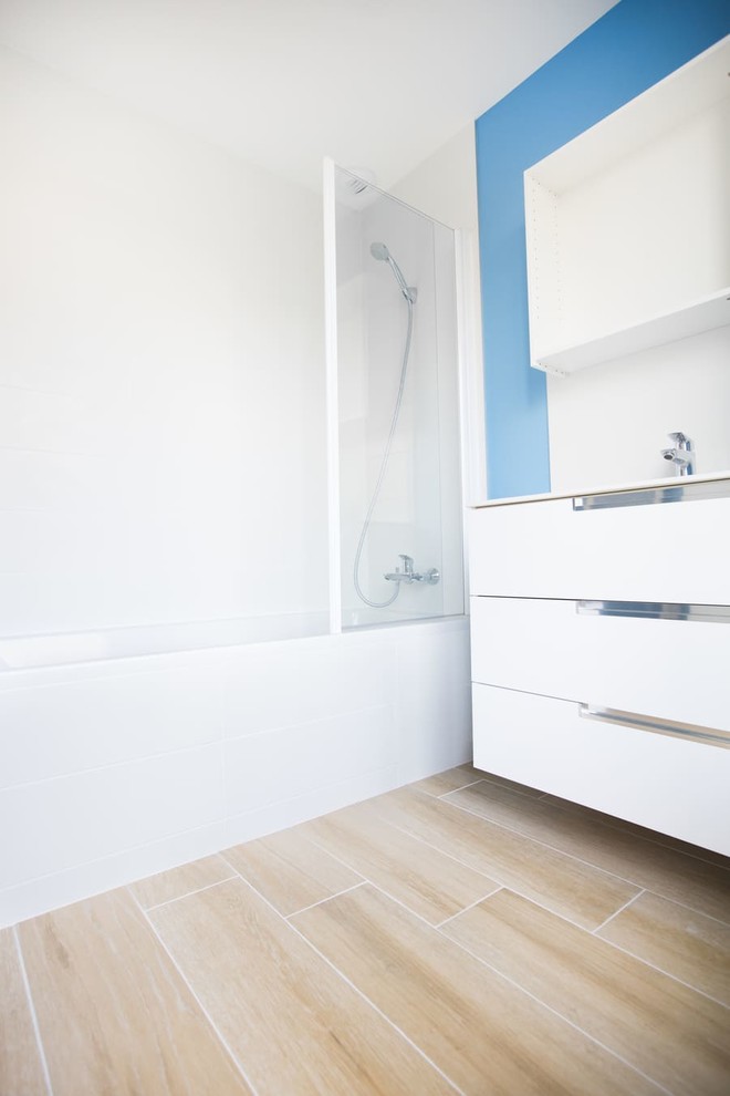 Idéer för ett litet modernt vit en-suite badrum, med luckor med profilerade fronter, vita skåp, ett badkar i en alkov, en dusch/badkar-kombination, vit kakel, blå väggar, klinkergolv i keramik, ett undermonterad handfat, beiget golv och dusch med gångjärnsdörr