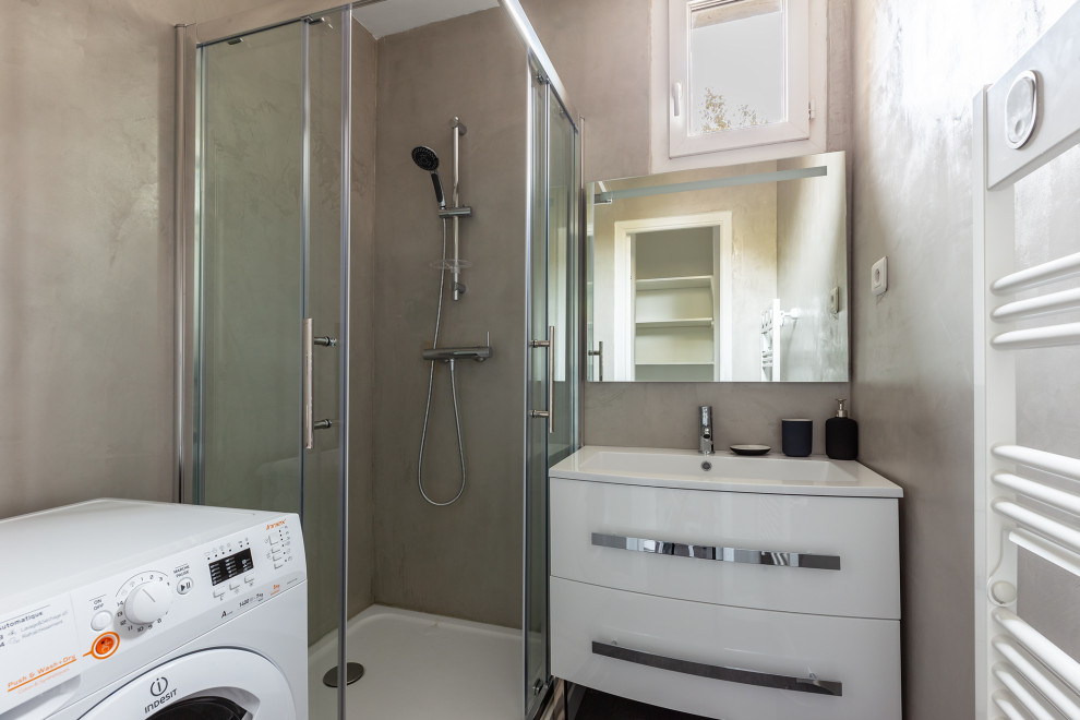 Cette photo montre une petite salle de bain tendance avec un carrelage beige, une cabine de douche à porte coulissante et un plan de toilette blanc.