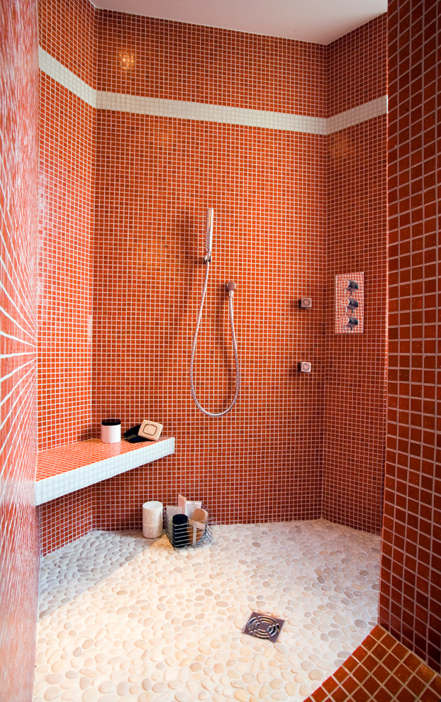 Пример оригинального дизайна: ванная комната среднего размера в современном стиле с душевой кабиной, открытым душем, красной плиткой, красными стенами, полом из галечной плитки и открытым душем