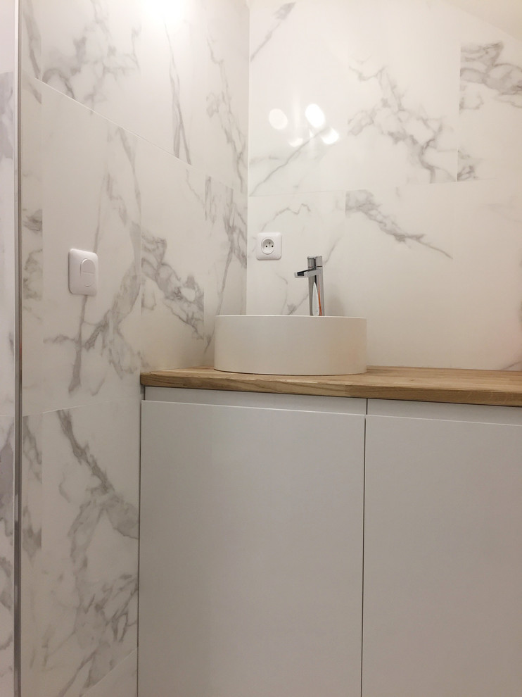 Small scandinavian ensuite bathroom in Paris with beaded cabinets, white cabinets, a built-in shower, white tiles, marble tiles, white walls, porcelain flooring, a built-in sink, wooden worktops, white floors and a hinged door.
