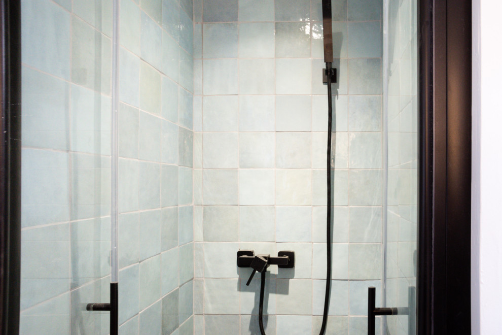 Inspiration för små eklektiska vitt badrum med dusch, med luckor med profilerade fronter, skåp i ljust trä, en dusch i en alkov, en toalettstol med separat cisternkåpa, blå kakel, perrakottakakel, vita väggar, klinkergolv i keramik, ett nedsänkt handfat, svart golv och dusch med gångjärnsdörr