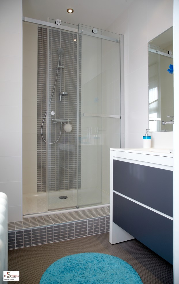 This is an example of a small contemporary family bathroom in Lille with an alcove shower, beige tiles, porcelain tiles, white walls, lino flooring, a console sink, solid surface worktops, beige floors and a sliding door.