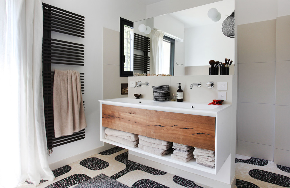 На фото: ванная комната в современном стиле с открытыми фасадами, белыми стенами, монолитной раковиной, разноцветным полом и зеркалом с подсветкой