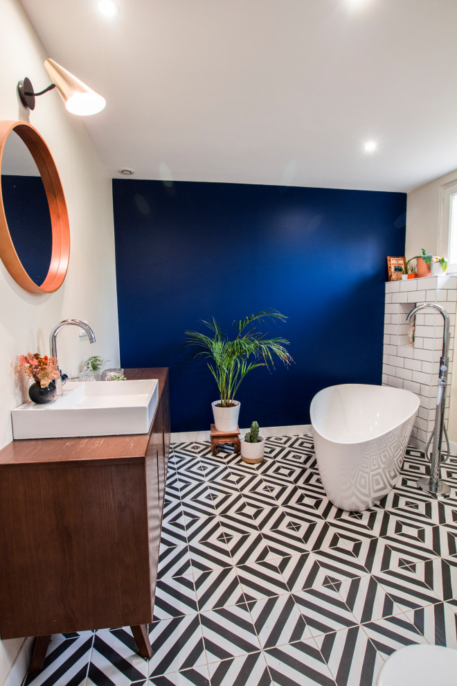 Large eclectic ensuite bathroom in Bordeaux with a built-in bath, a corner shower, black and white tiles, metro tiles, blue walls, terracotta flooring, a built-in sink, wooden worktops and multi-coloured floors.