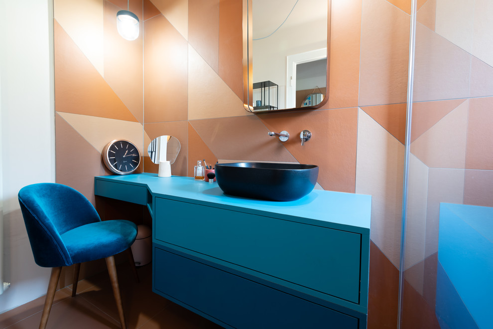 Источник вдохновения для домашнего уюта: главная ванная комната среднего размера в стиле модернизм с фасадами с декоративным кантом, синими фасадами, душем без бортиков, оранжевой плиткой, цементной плиткой, оранжевыми стенами, полом из цементной плитки, настольной раковиной, столешницей из ламината, оранжевым полом, открытым душем, синей столешницей, раздельным унитазом, нишей, тумбой под одну раковину, подвесной тумбой, потолком с обоями, кирпичными стенами и отдельно стоящей ванной