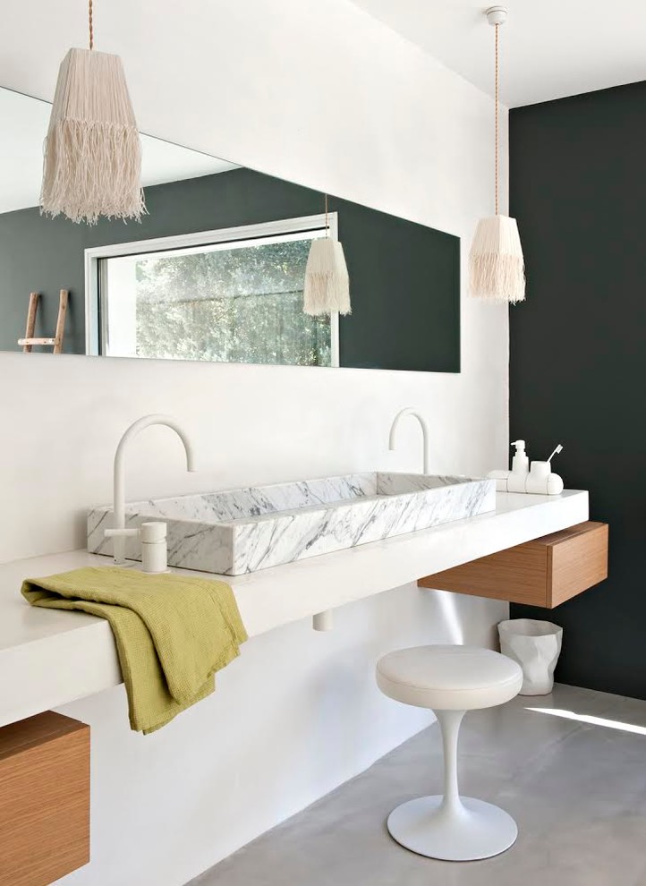 Bild på ett mellanstort funkis badrum, med ett avlångt handfat, betonggolv och vita väggar