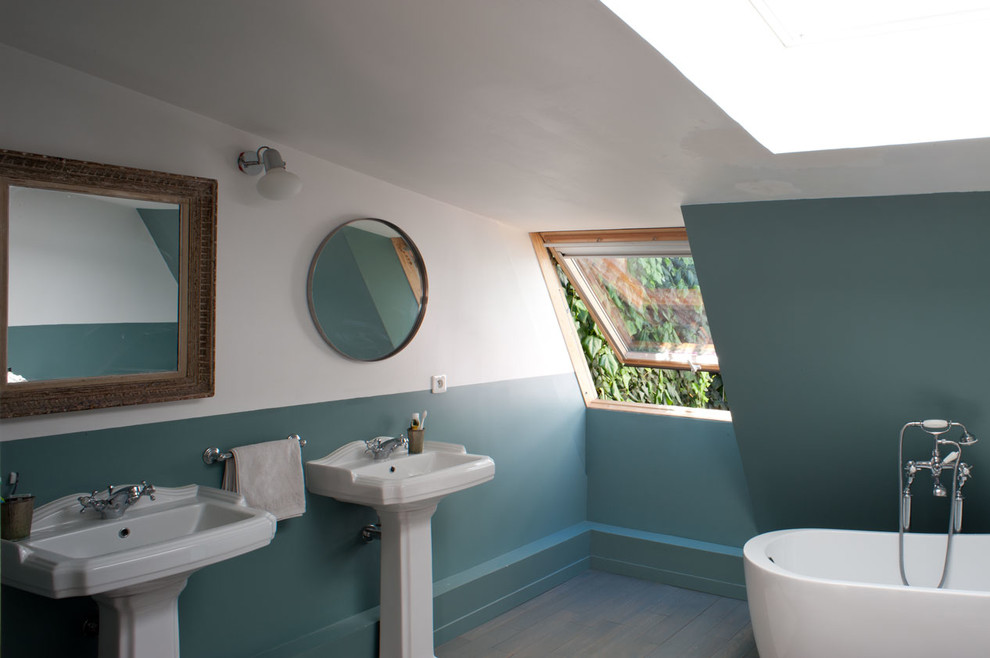 Exemple d'une salle de bain principale industrielle de taille moyenne avec un mur bleu, un sol en bois brun, une grande vasque, un sol marron, une cabine de douche à porte battante et un plan de toilette en stéatite.