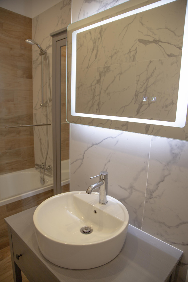 Imagen de cuarto de baño principal minimalista de tamaño medio con bañera encastrada sin remate, suelo de madera clara y lavabo encastrado
