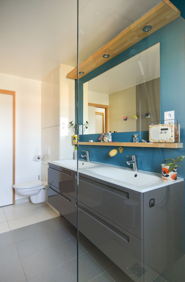Großes Modernes Duschbad mit flächenbündigen Schrankfronten, grauen Schränken, weißer Wandfarbe, Porzellan-Bodenfliesen, integriertem Waschbecken, grauem Boden, weißer Waschtischplatte, Doppelwaschbecken und schwebendem Waschtisch in Montpellier