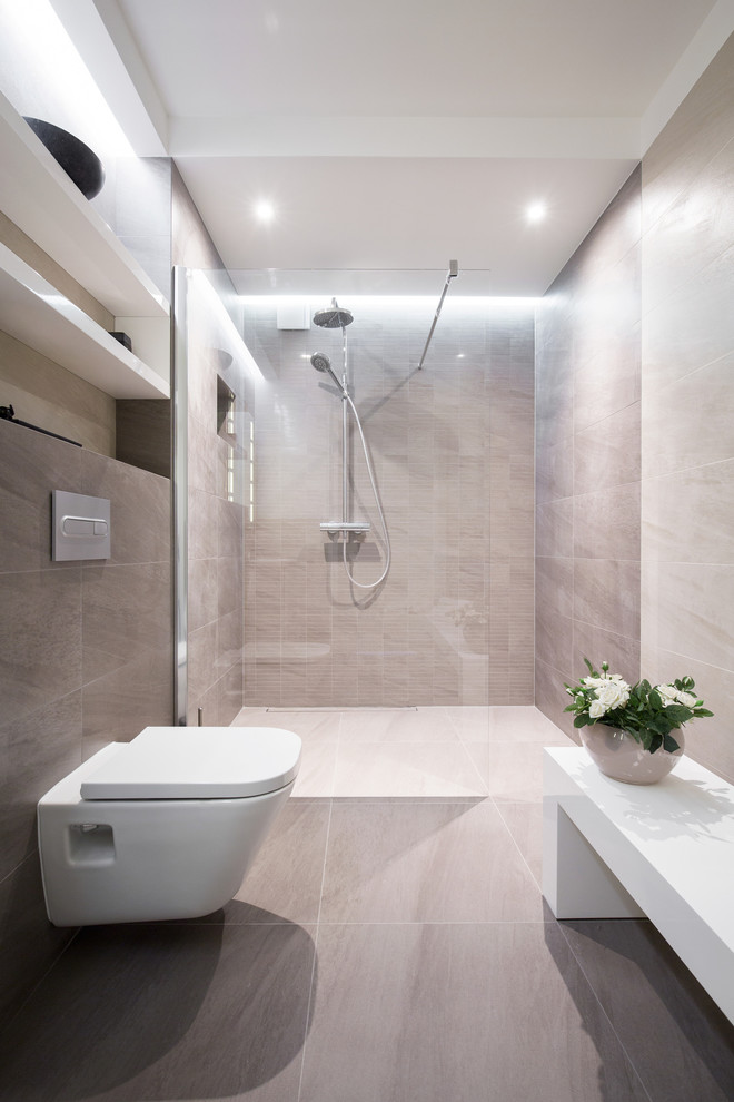 Inspiration för mellanstora moderna badrum med dusch, med en vägghängd toalettstol, beige kakel, keramikplattor, beige väggar, klinkergolv i keramik och en kantlös dusch