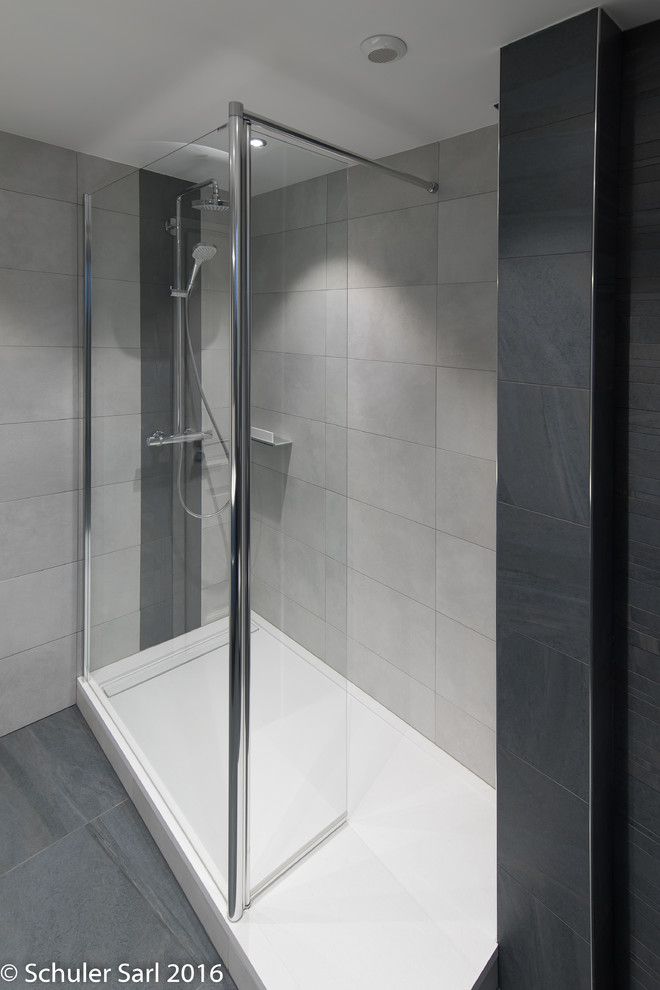 Modern inredning av ett mellanstort en-suite badrum, med en öppen dusch, en vägghängd toalettstol och keramikplattor