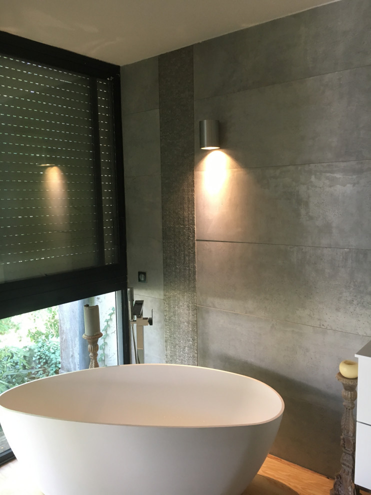 Inspiration for a large classic ensuite bathroom in Toulouse with white cabinets, a built-in shower, grey tiles, ceramic tiles, grey walls, light hardwood flooring, a console sink, solid surface worktops, an open shower, white worktops, double sinks and a floating vanity unit.