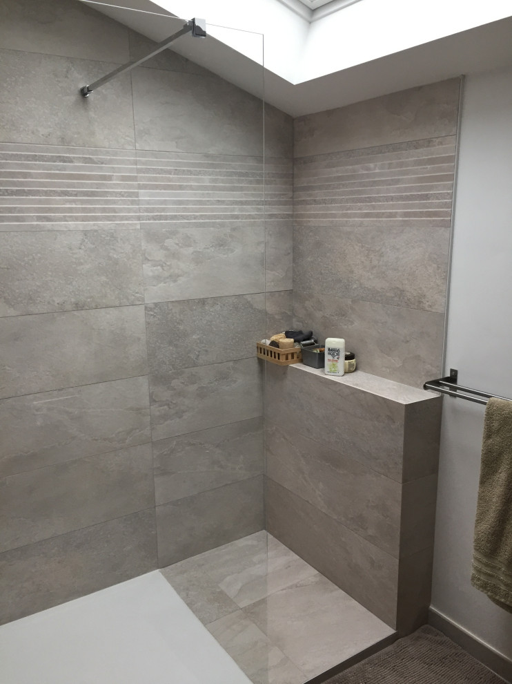 Foto på ett mellanstort funkis brun badrum med dusch, med skåp i mörkt trä, en kantlös dusch, grå kakel, vita väggar, vinylgolv, ett fristående handfat, träbänkskiva och grått golv